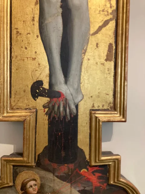 Detail van een kruisbeeld met gouden omlijsting.